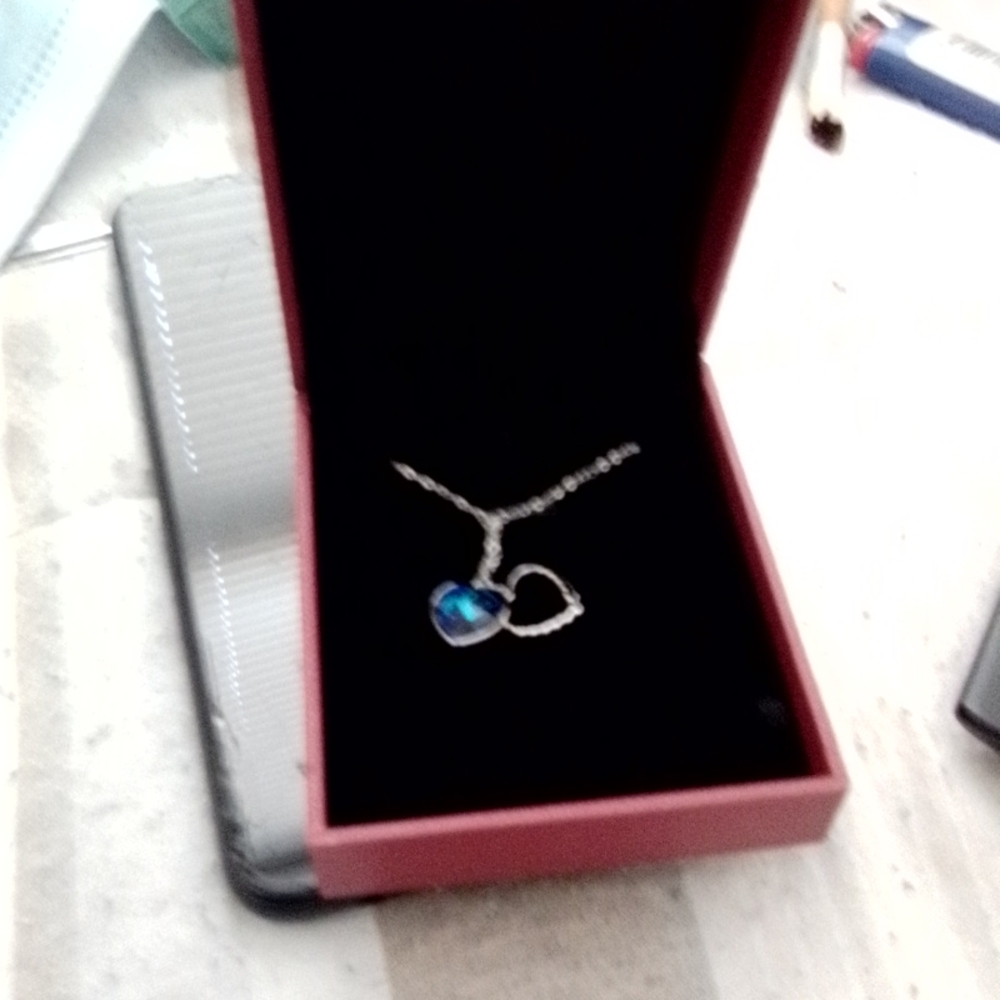 Silver chain with a blue heart shaped pendant in box